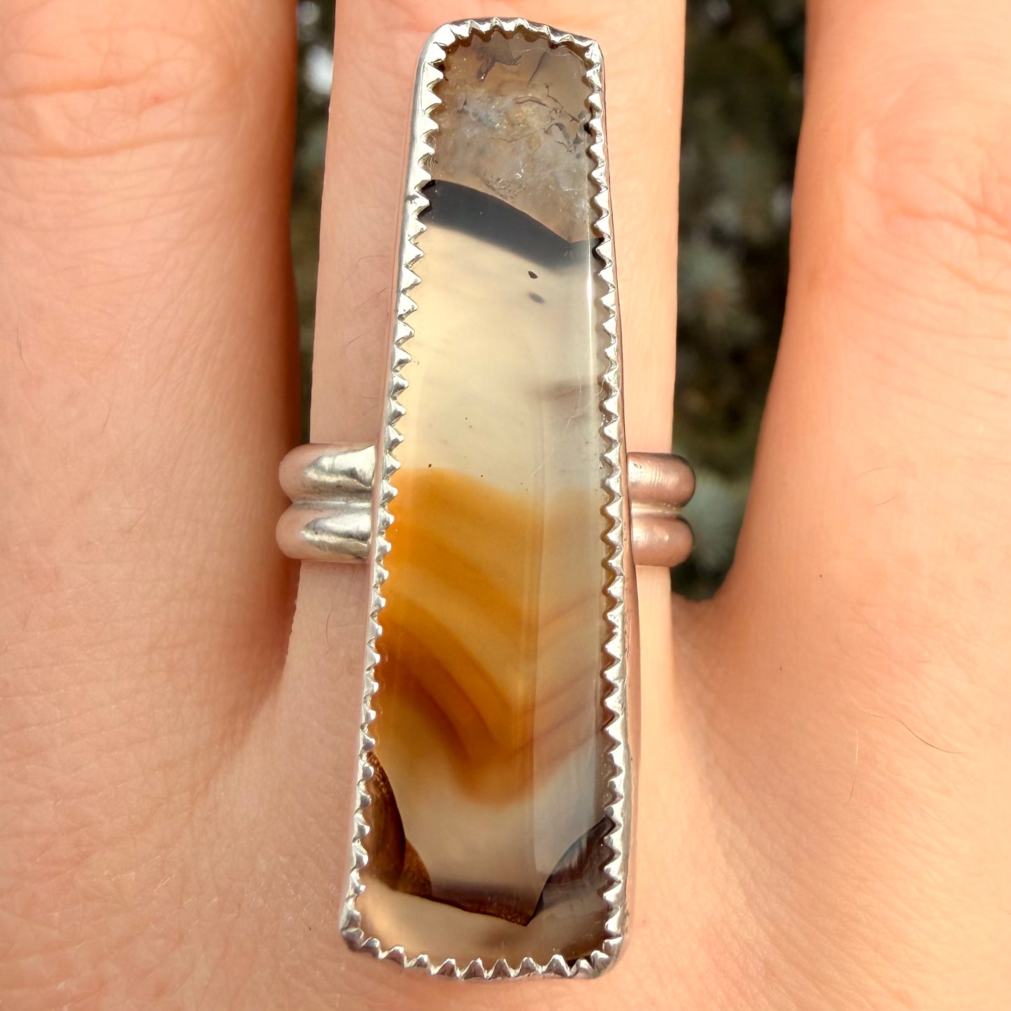Silver ring with a stone on a finger